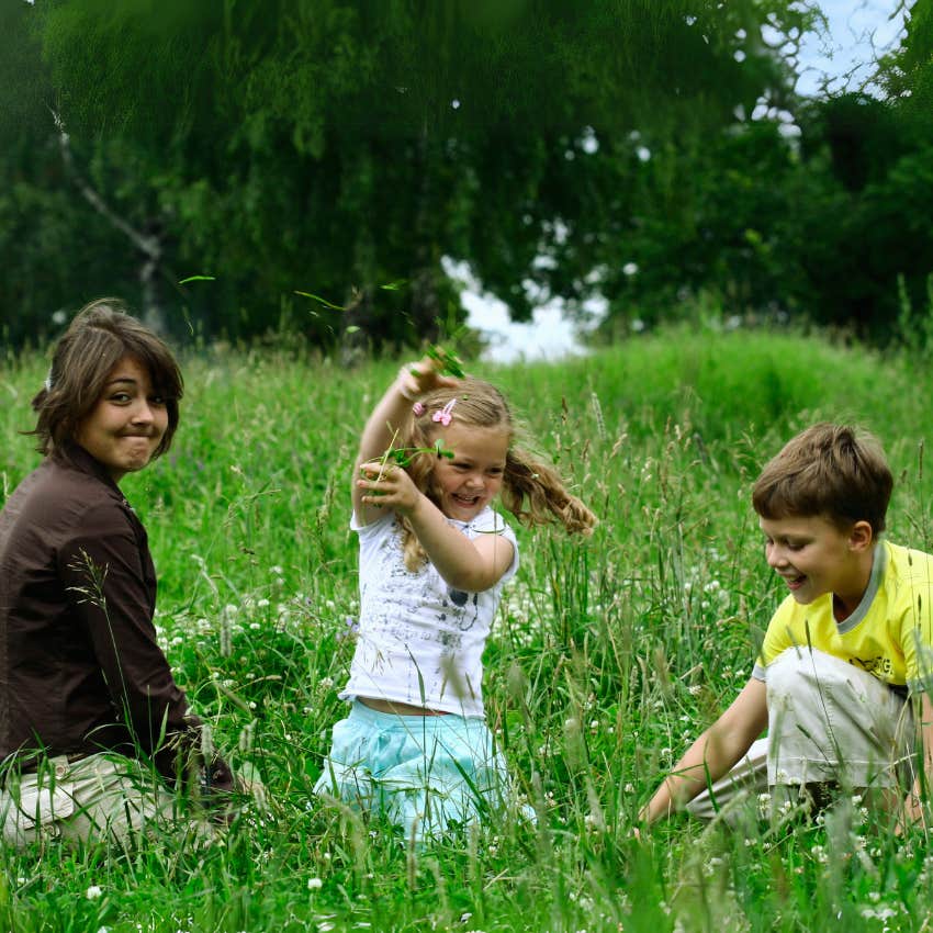 siblings playing in a field