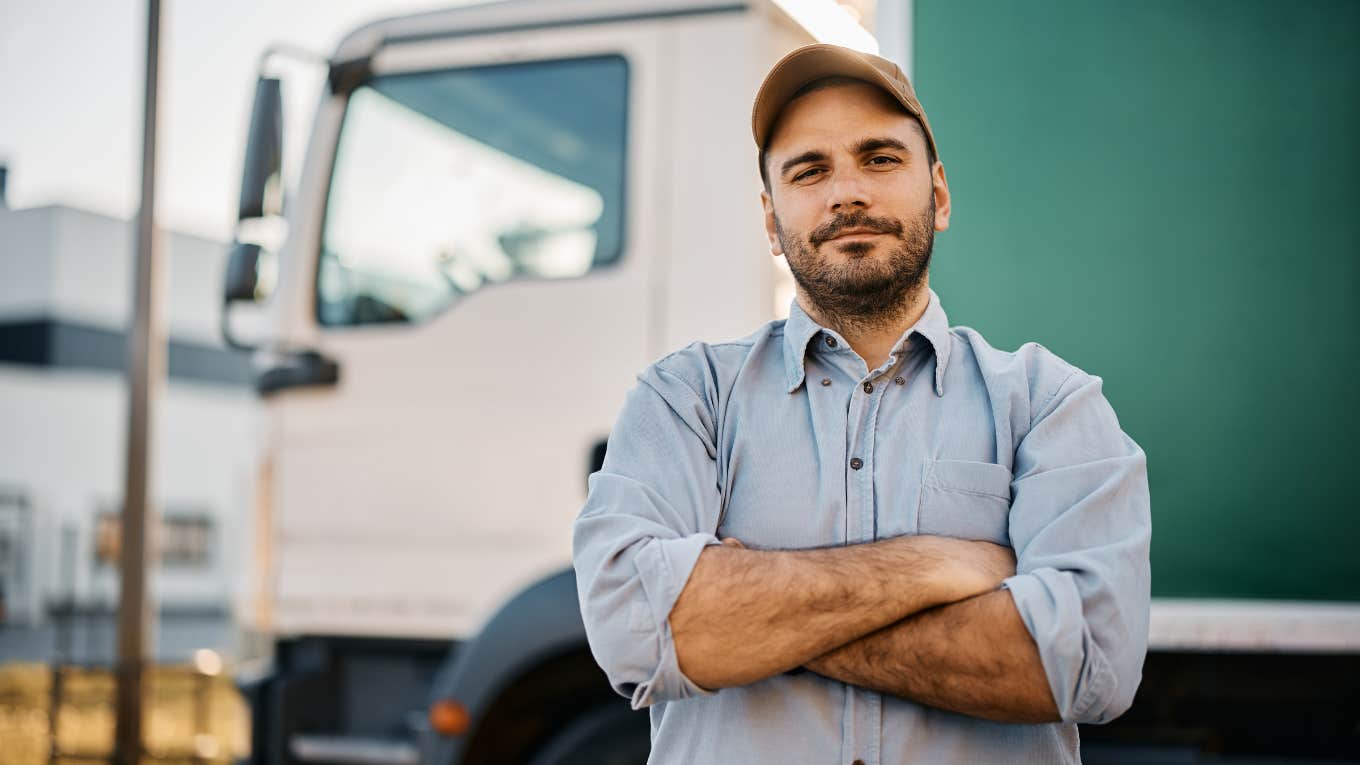 confident truck driver on parking lot looking at camera