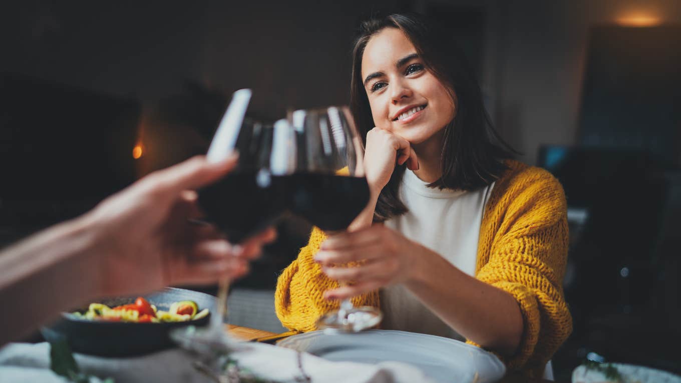 couple making cheers with glasses of red wine during romantic dinner