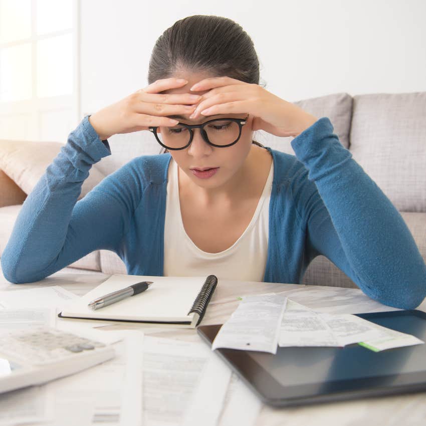 Woman looking stressed while doing her bills. 