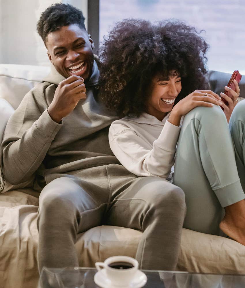 man and woman smiling on couch 