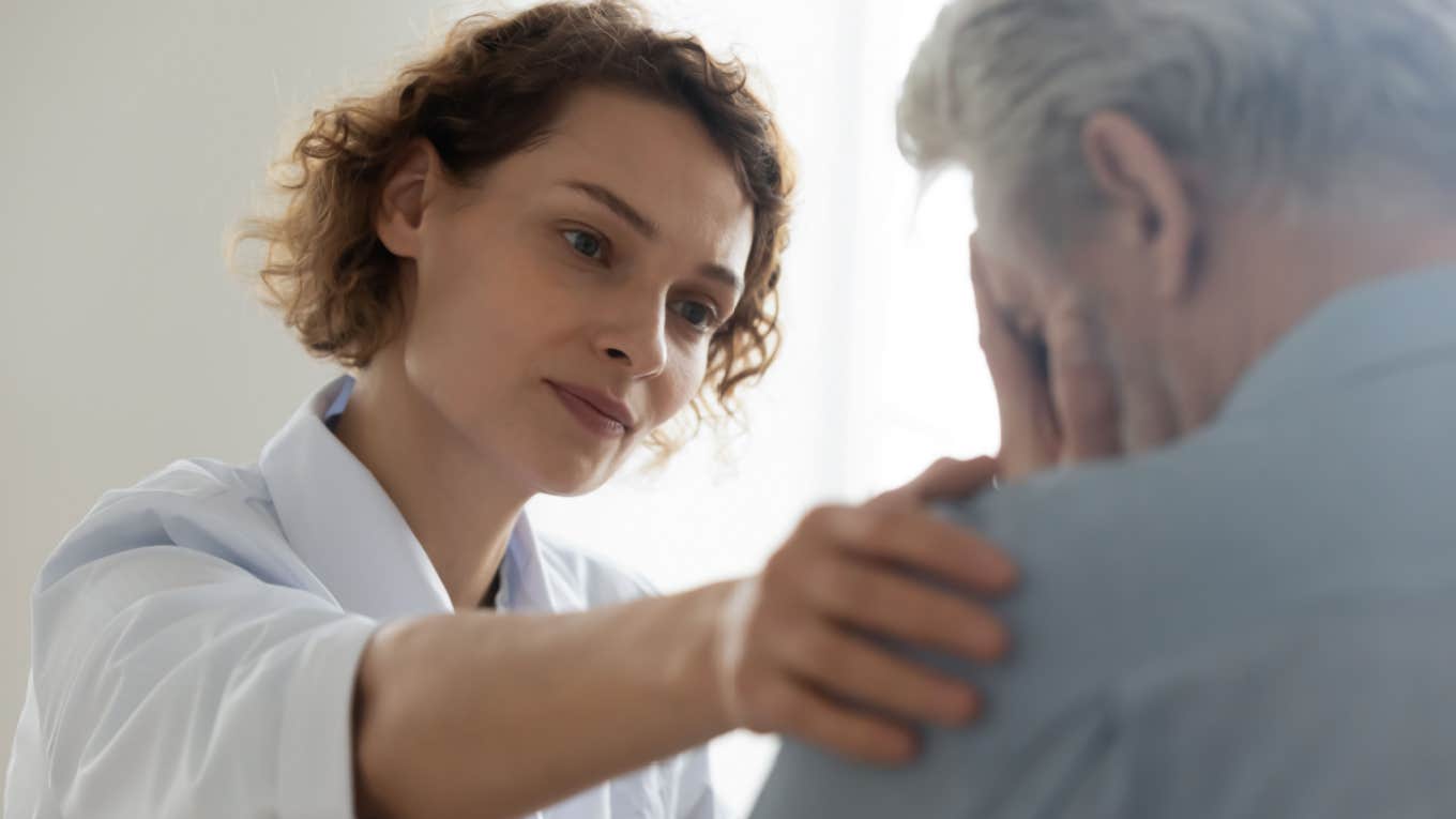 nurse comforts emotional elderly patient