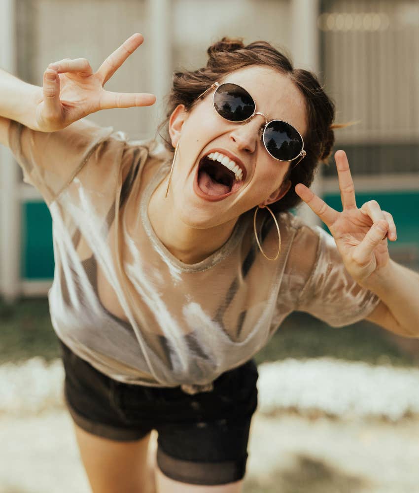 girl smiling and giving peace signs