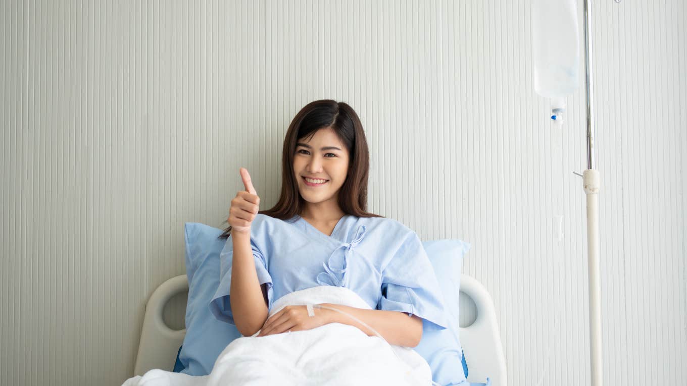 woman sitting up in hospital bed giving thumbs up