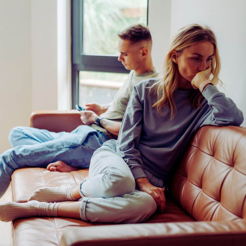 couple sitting on a couch ignoring each other