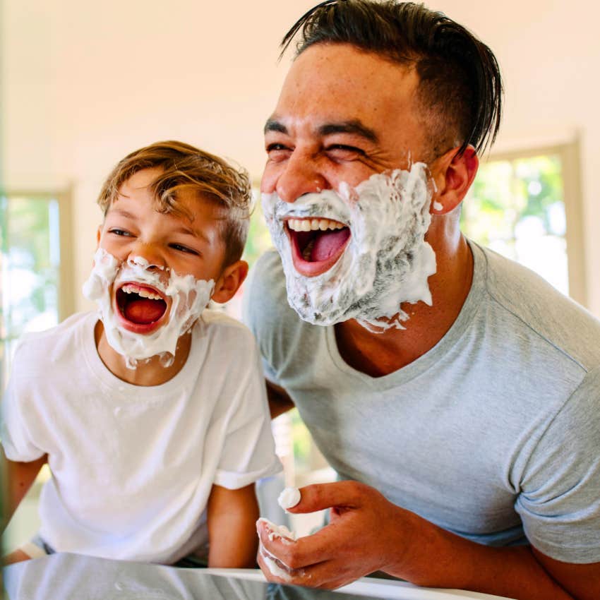 father and young son shaving together and laughing