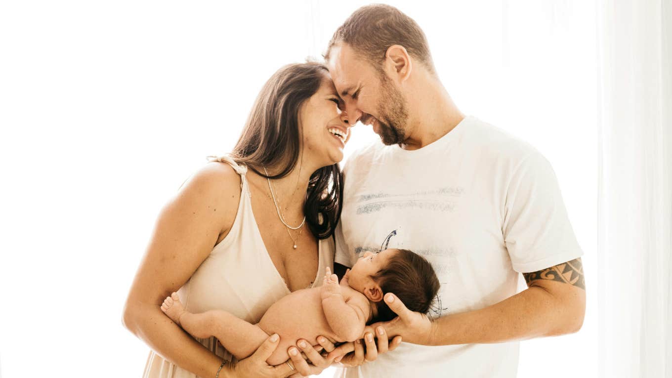 mom and dad holding baby