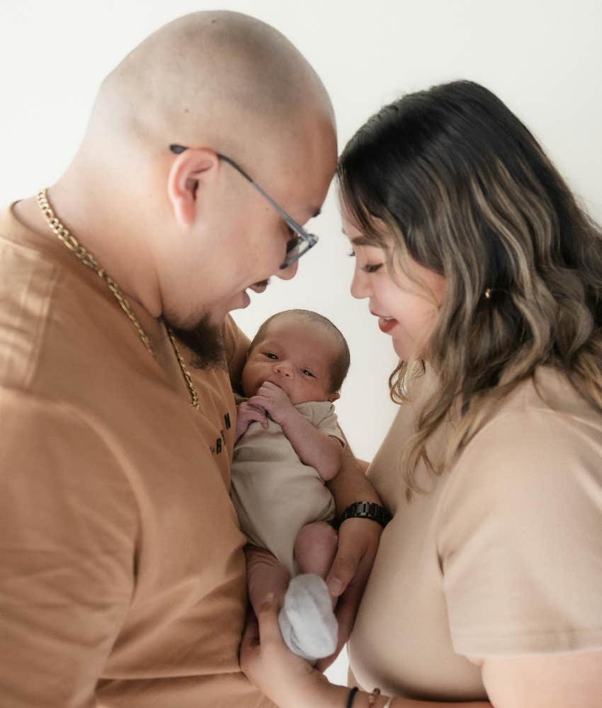 mom and dad holding baby