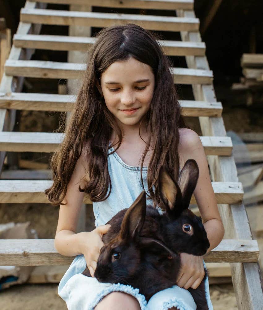 Young girl holding rabbits