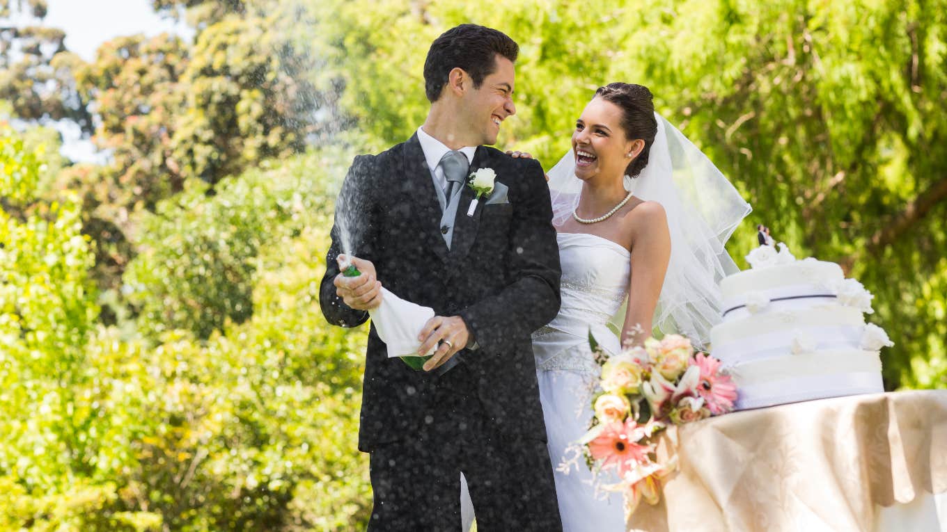 Groom spraying champagne at wedding