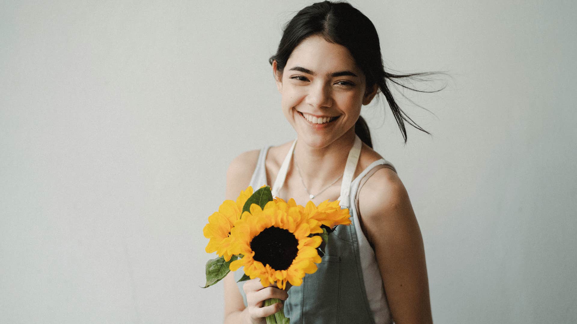 happy optimistic woman holding sunflower
