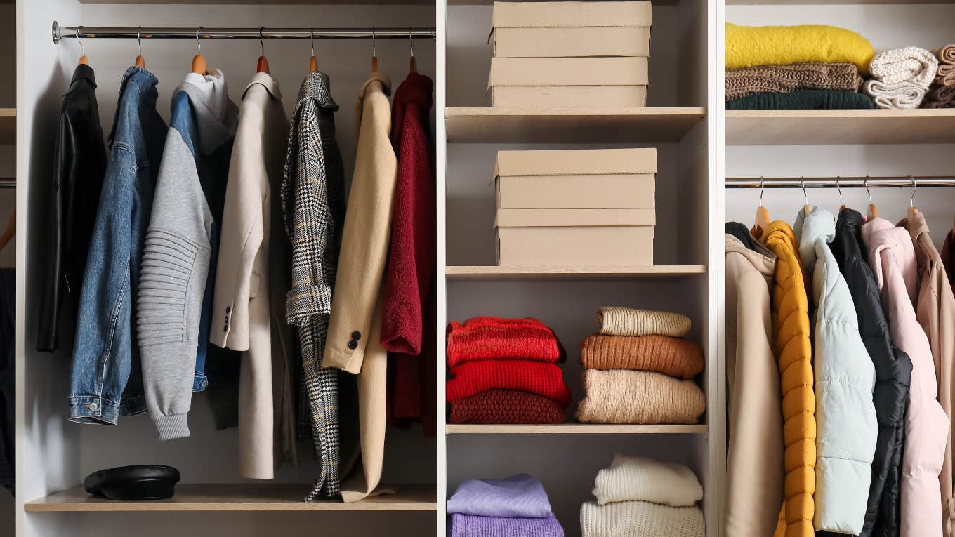 closet with winter coats, sweaters and boxes