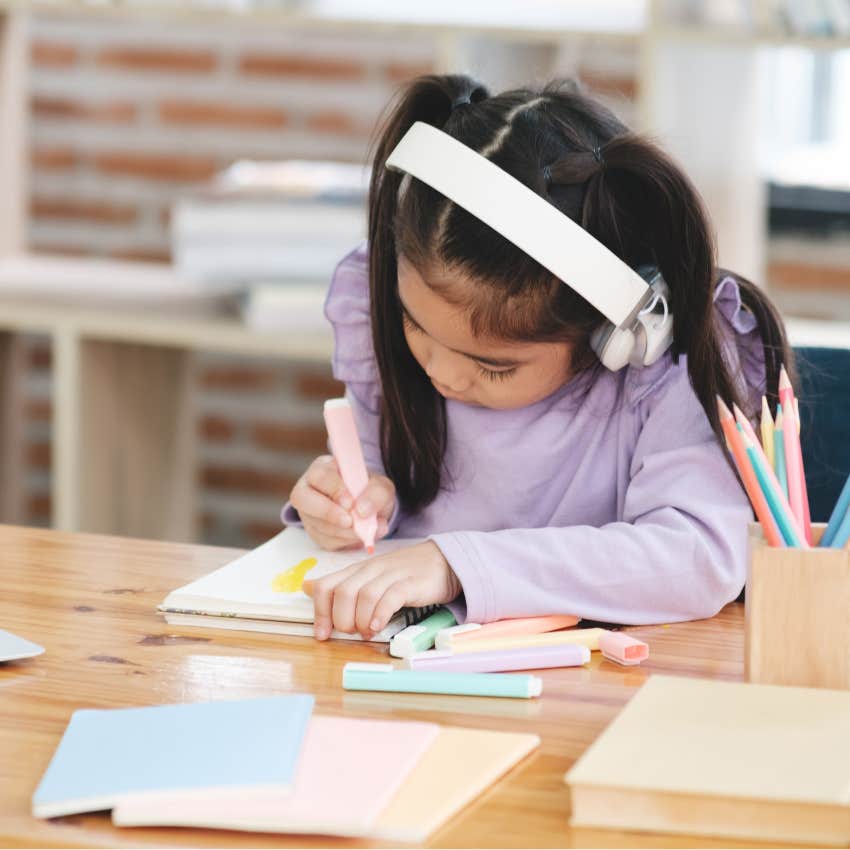 Little girl learning with headphones at a home daycare. 