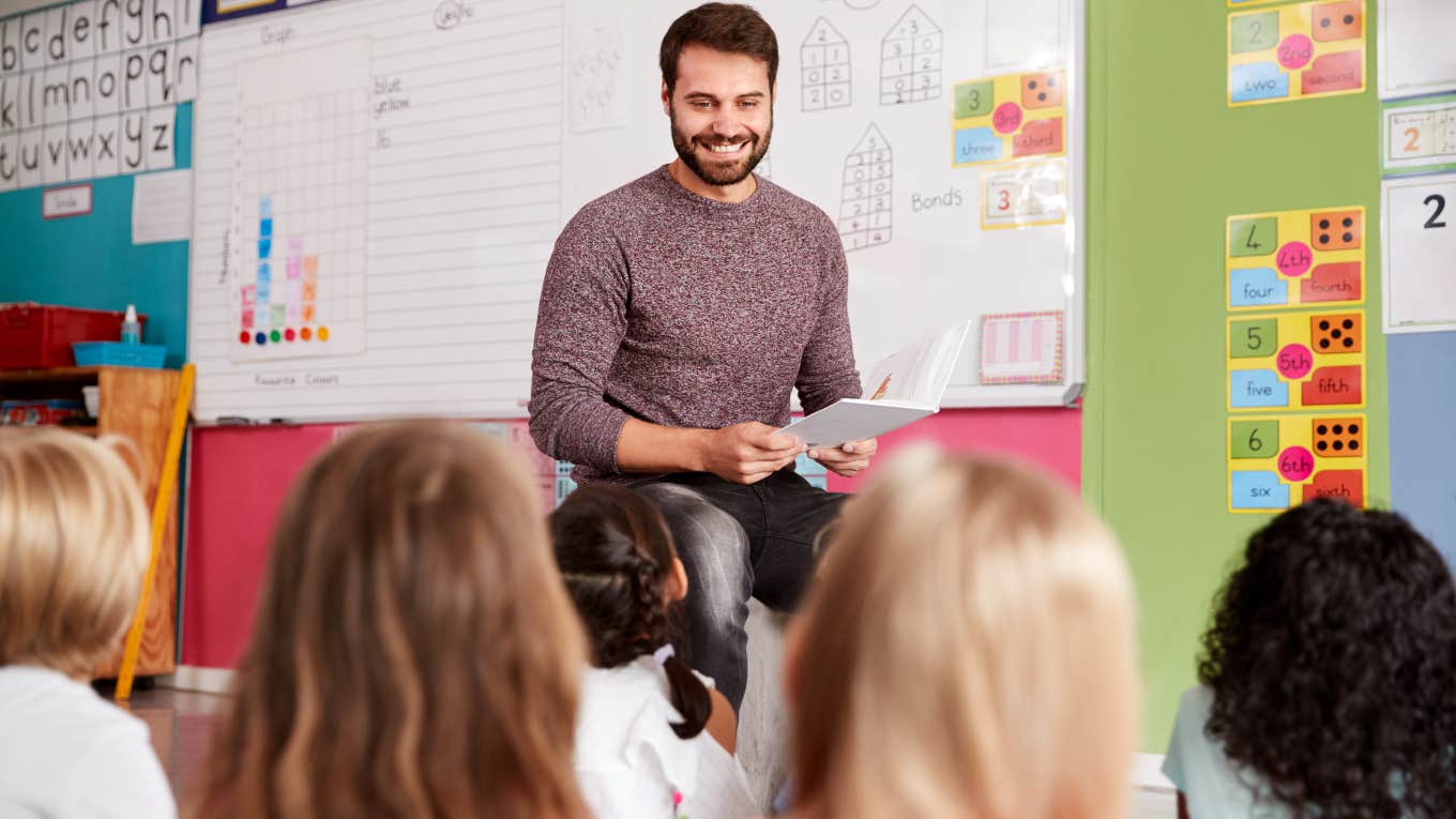 male teacher reading to his class