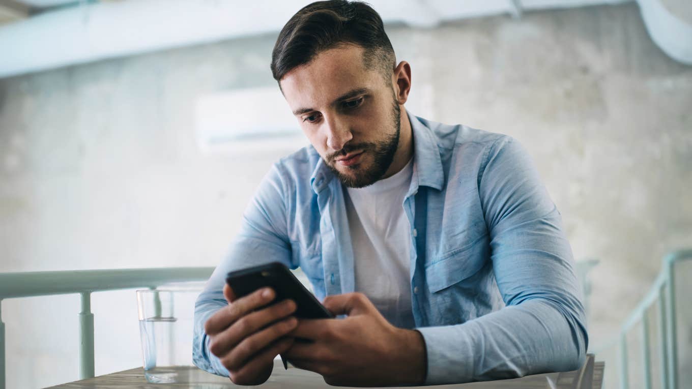 Man looking bored while watching short-form content on phone. 