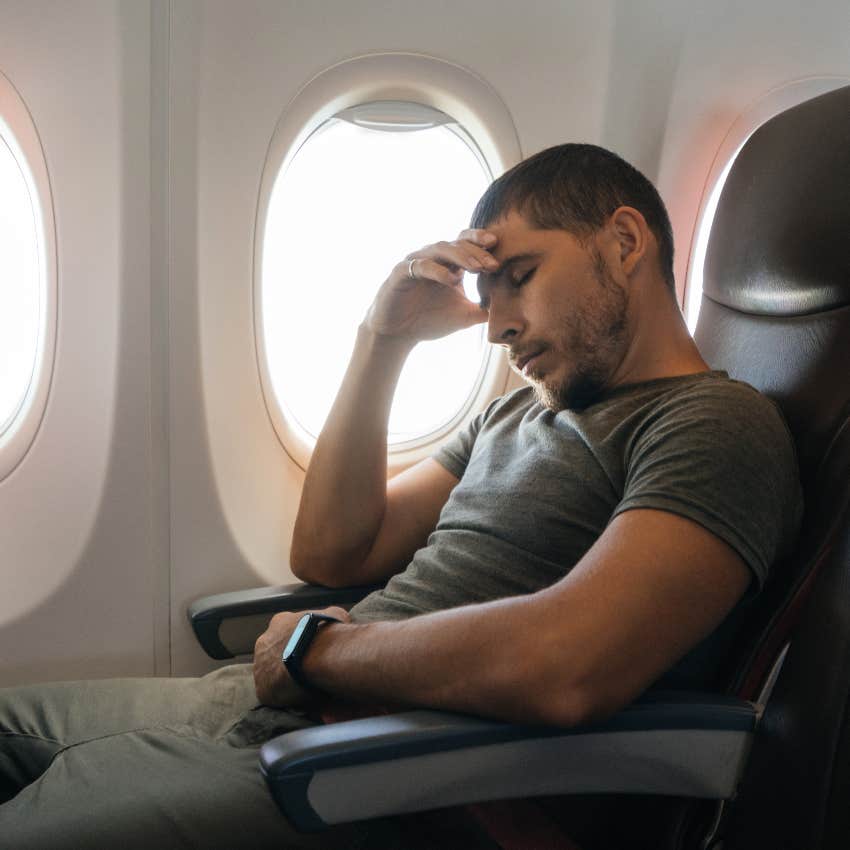 Man sleeping in window seat on airplane
