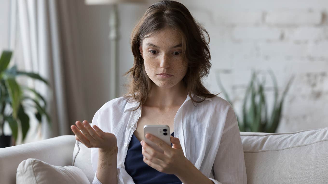 Employee looking annoyed while texting micromanaging boss on her phone. 