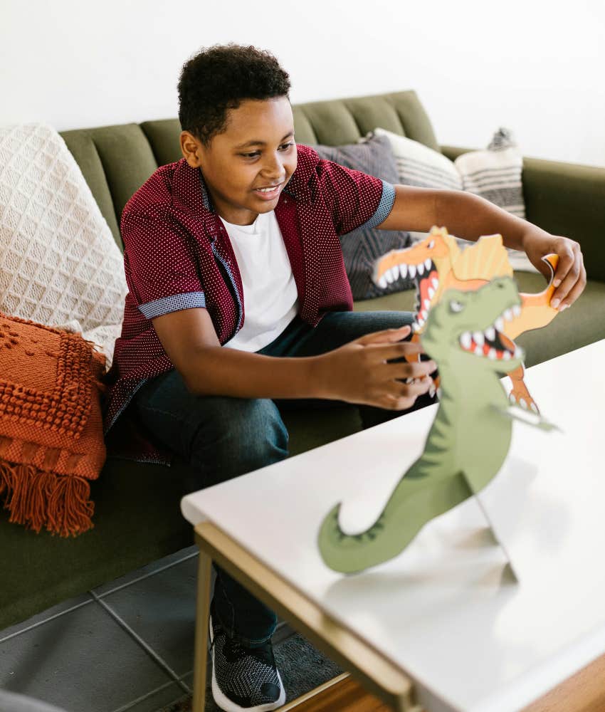 boy playing with a dinosaur toy