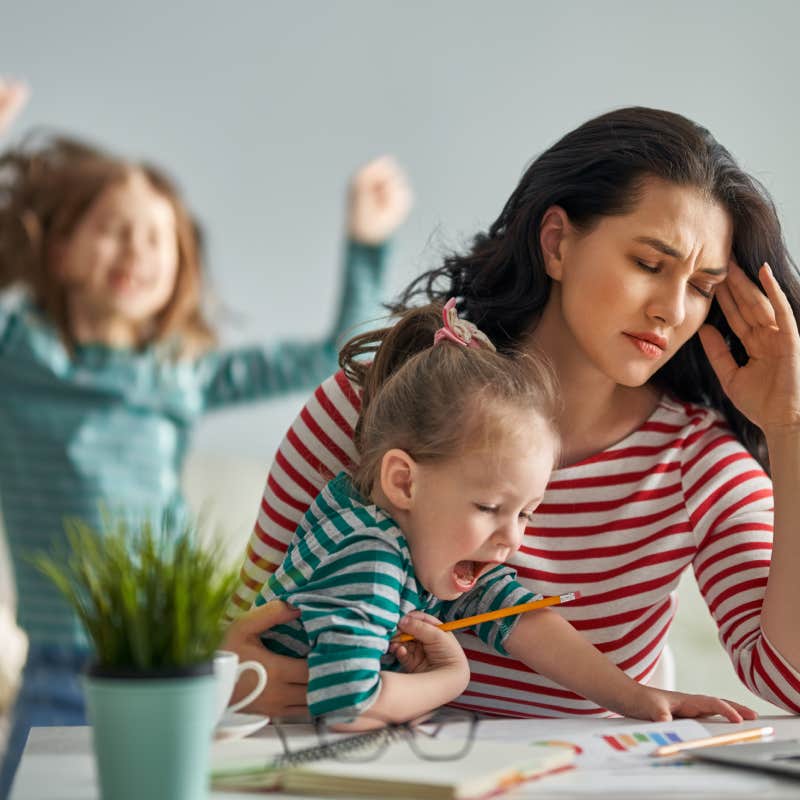 stressed woman working with kids in background