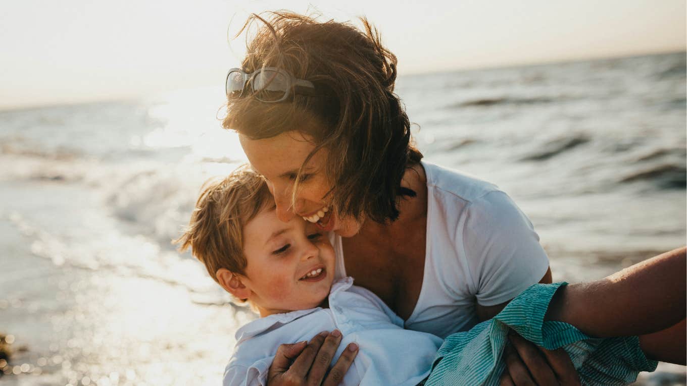 woman holding her child at the beach 