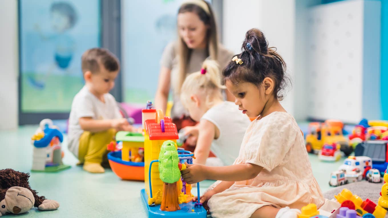 toddlers and teacher playing with toys in daycare