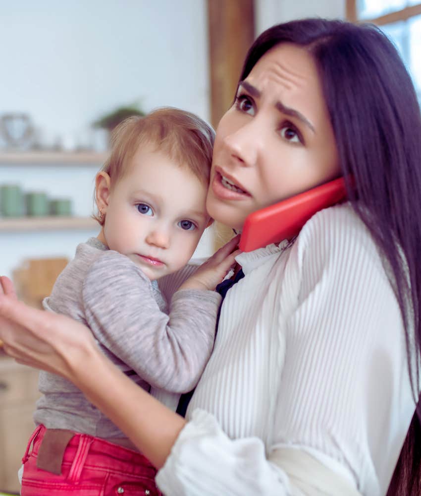 mom holding baby and talking on the phone