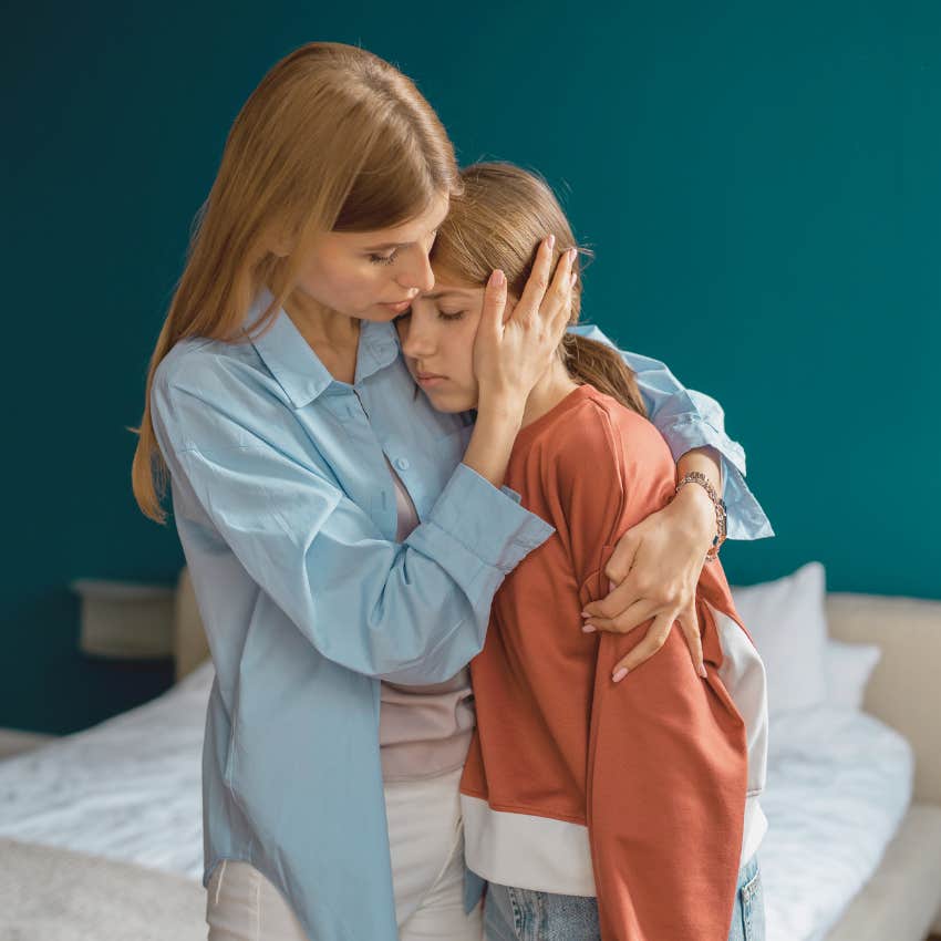 mom hugging teen daughter who is upset