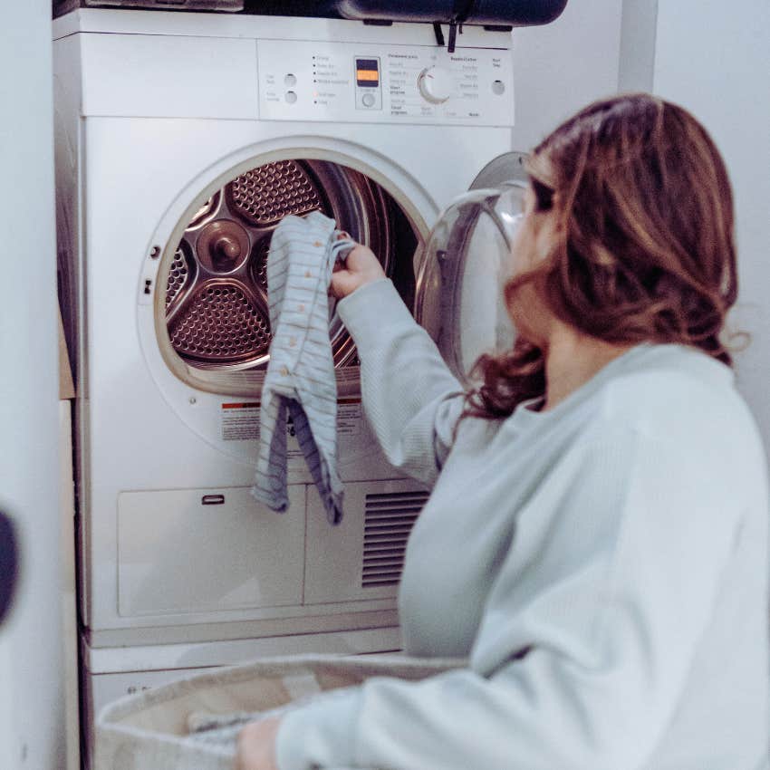 mom loading clothes into dryer