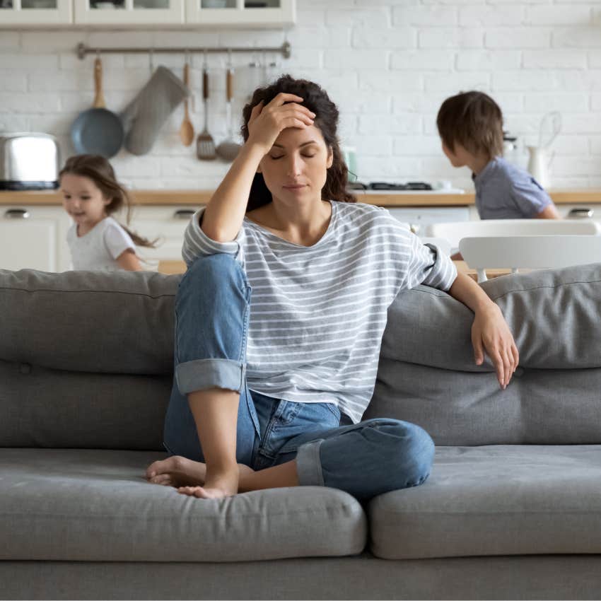 Mom looking stressed with her kids running around. 