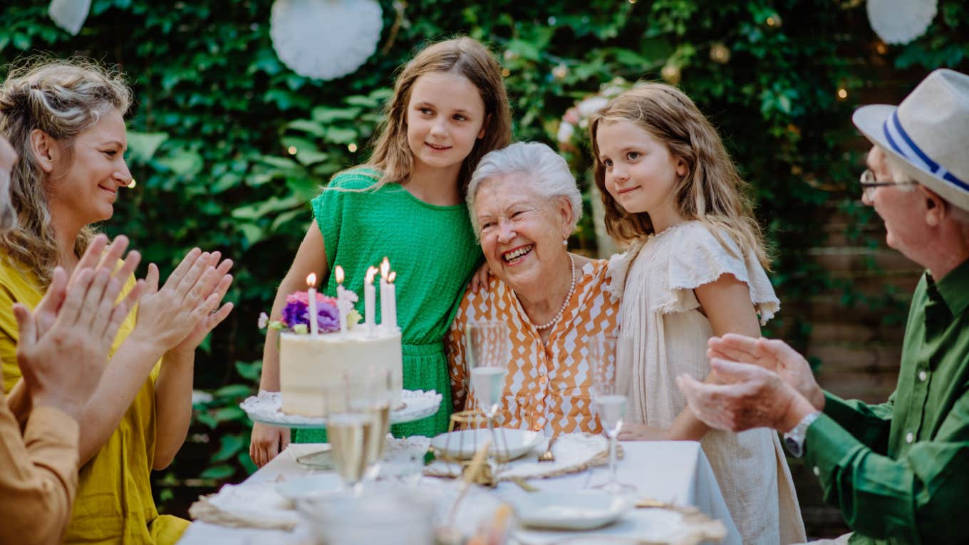 grandma poses with granddaughters at birthday party