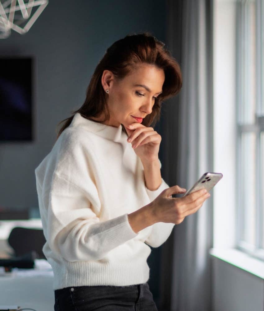 woman looking at her phone with serious expression