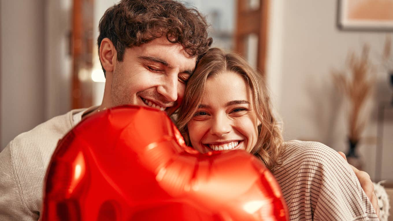 couple hugging each other with a heart balloon between them