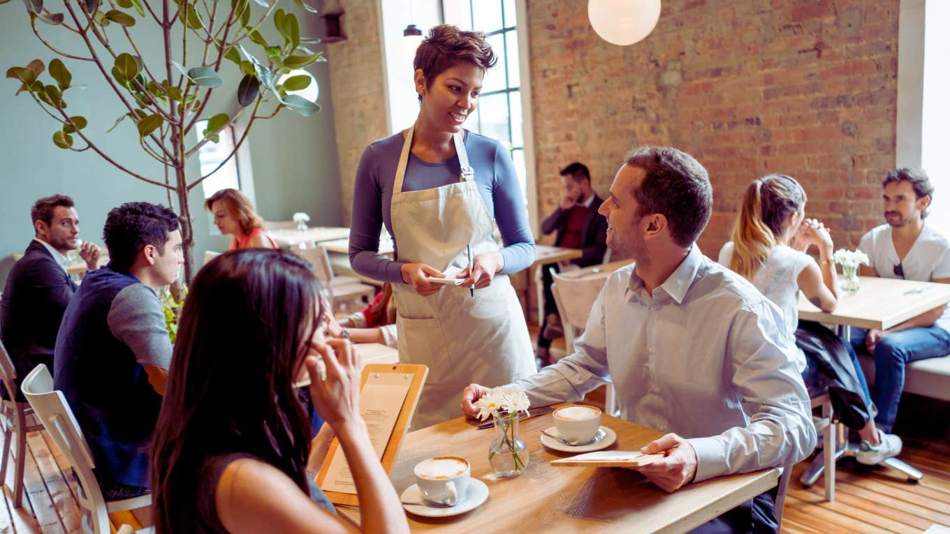 waitress speaking to couple at a table