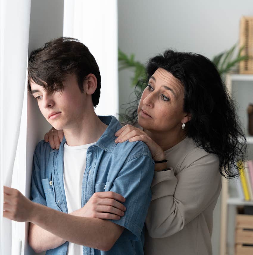 Mother comforts sad son because parenting teens is challenging