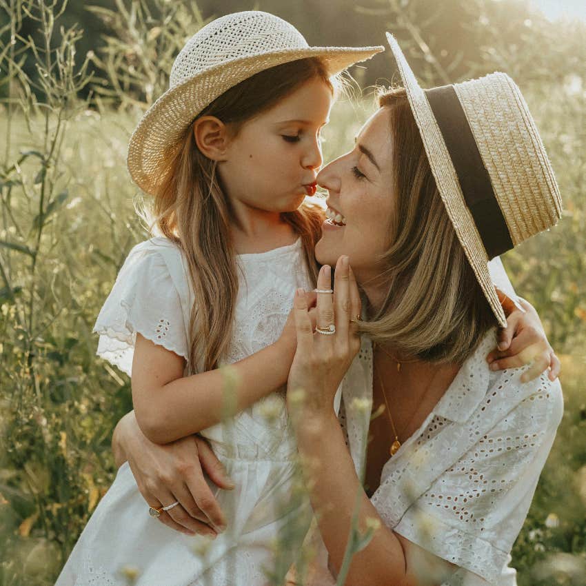 girl and mom hugging in a field