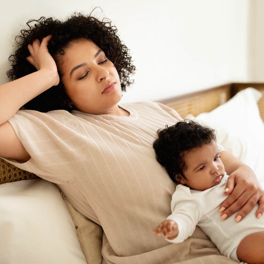 Stressed mother holding her baby and thinking about bills. 