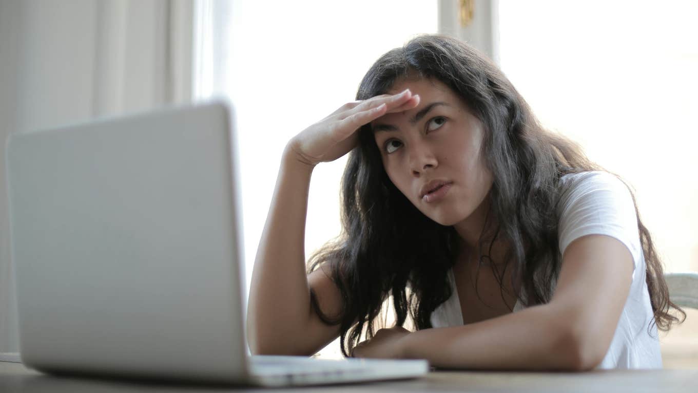 woman using laptop looking stressed