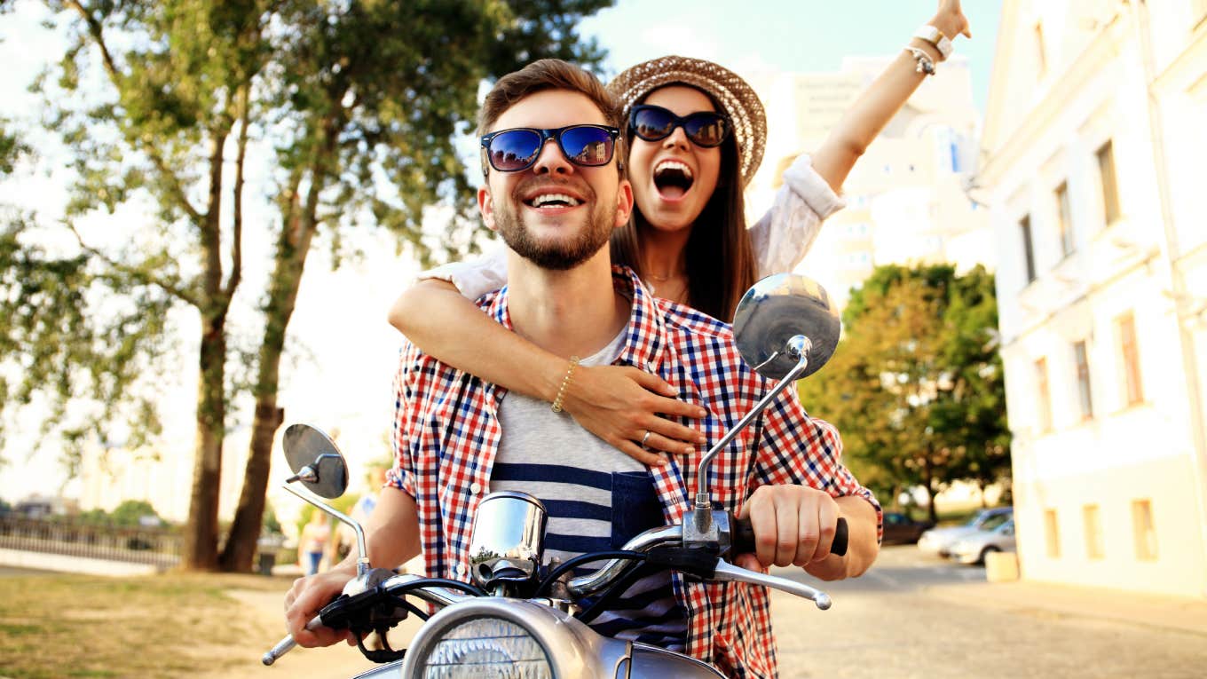 couple riding on motorcycle while on vacation