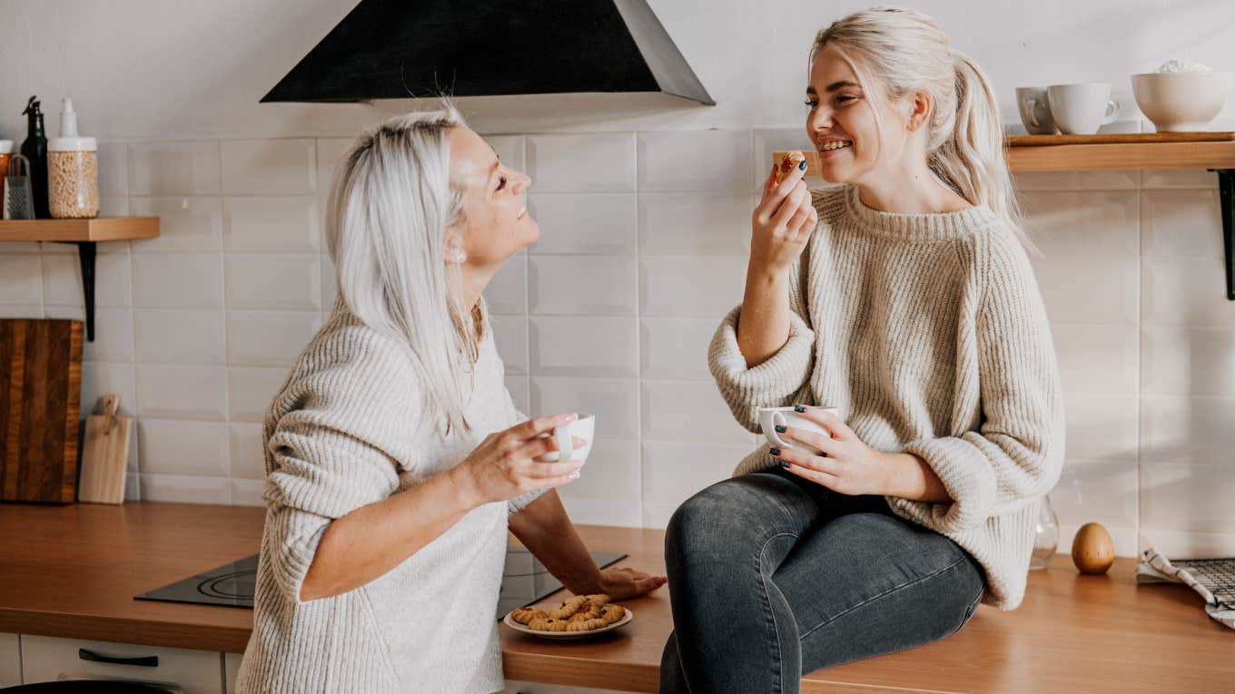 Teenage girl sitting with her mother in the kitchen. 