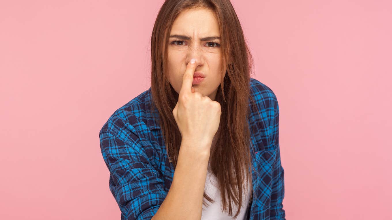 woman pointing at her nose implying someone is lying