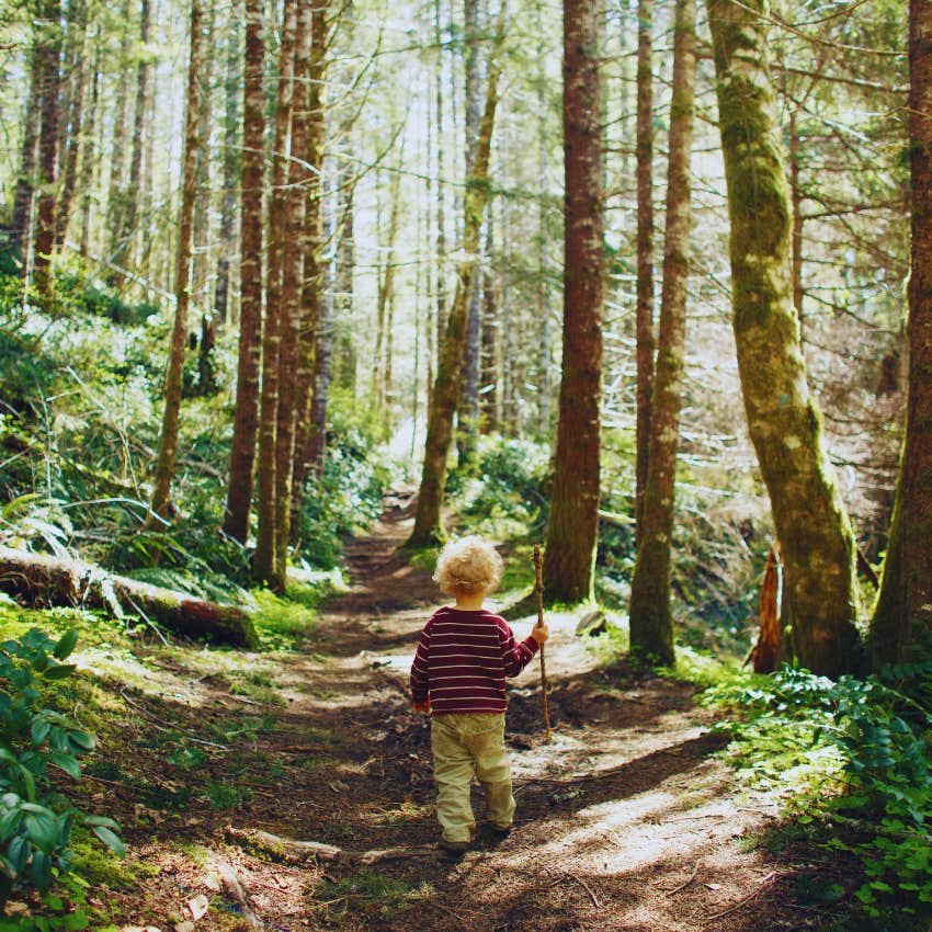 toddler walking down a trail in the woods