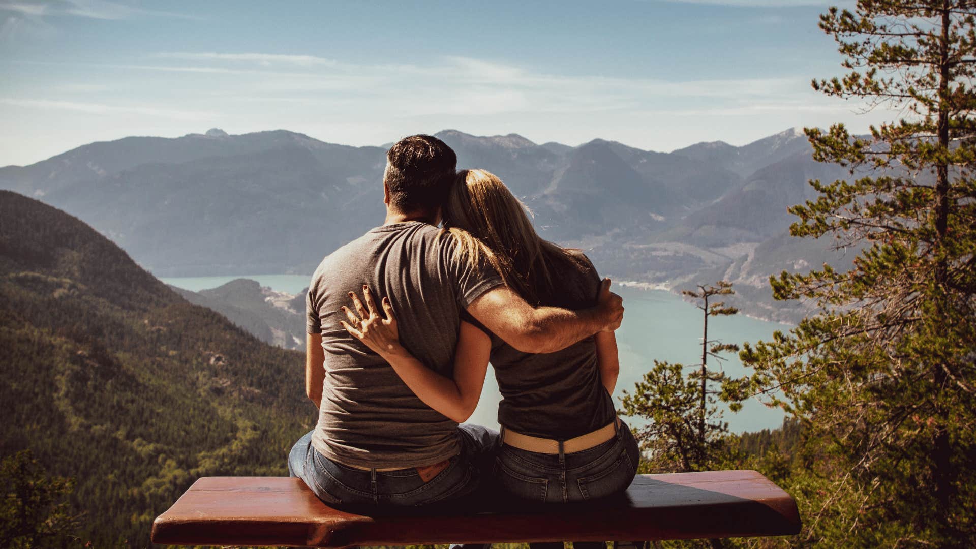 couple holding one another in front of scenic landscape