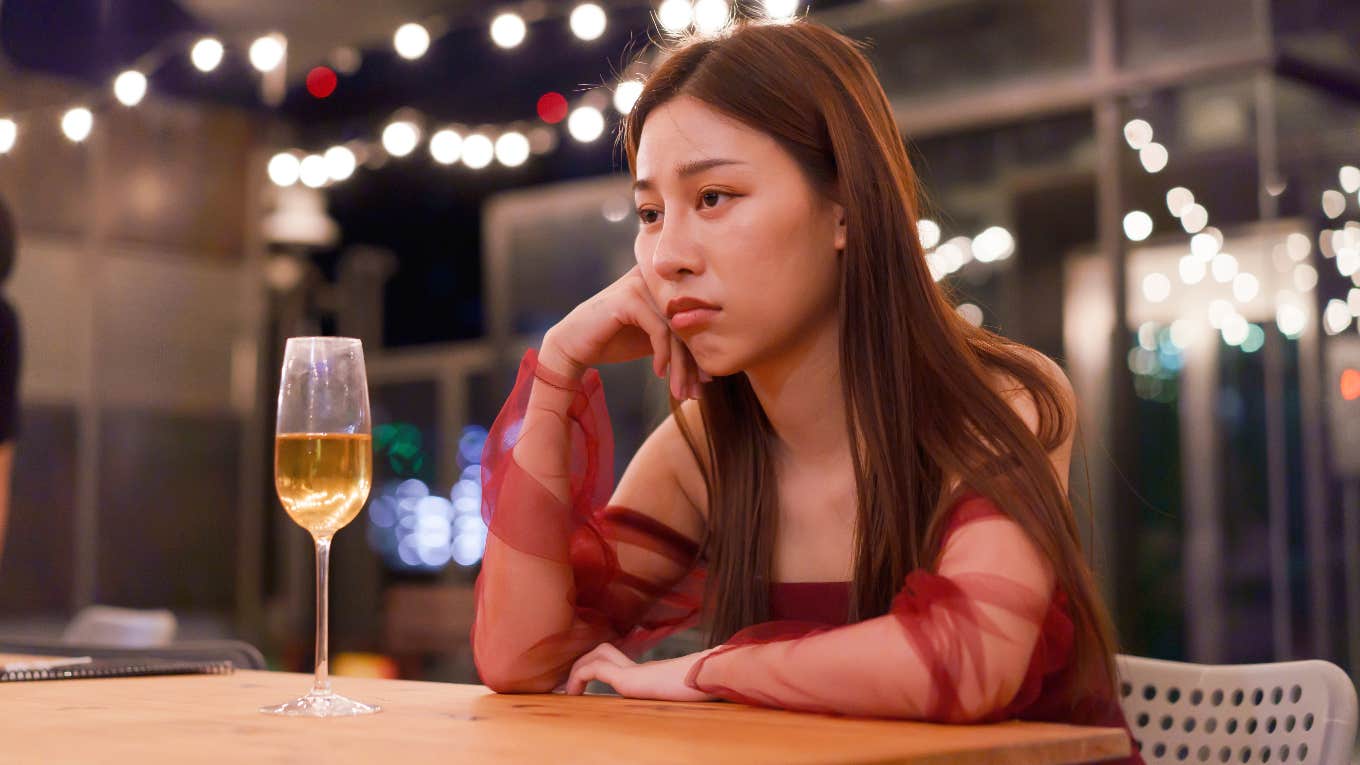 woman drinking alone looking upset