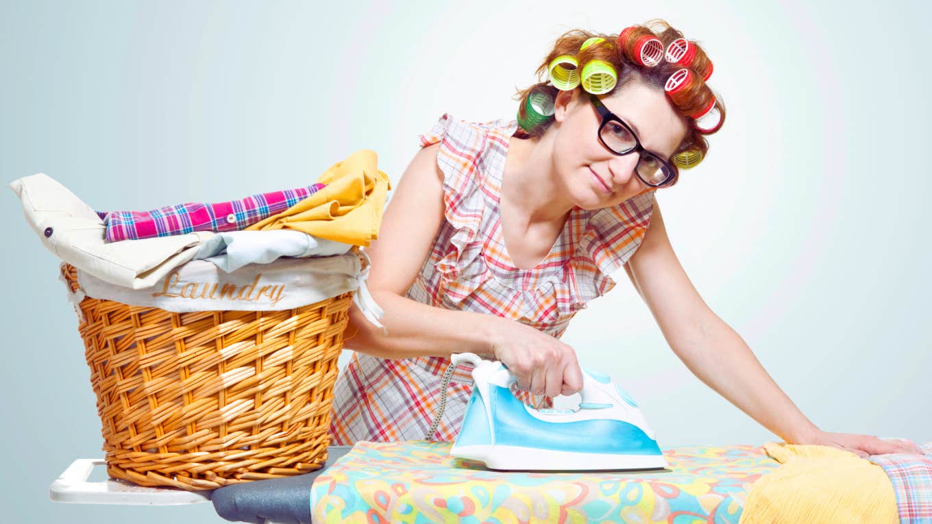 comical depiction of traditional housewife ironing clothes with curlers in her hair