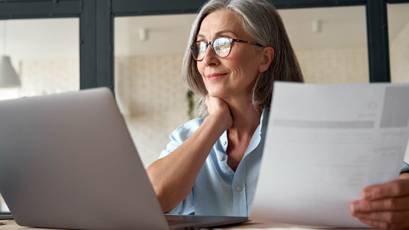 middle aged business woman using laptop working on computer sitting at desk.