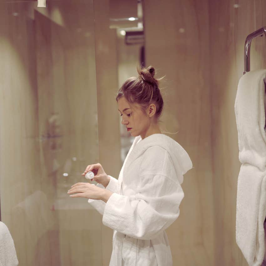 woman standing in a robe in the bathroom