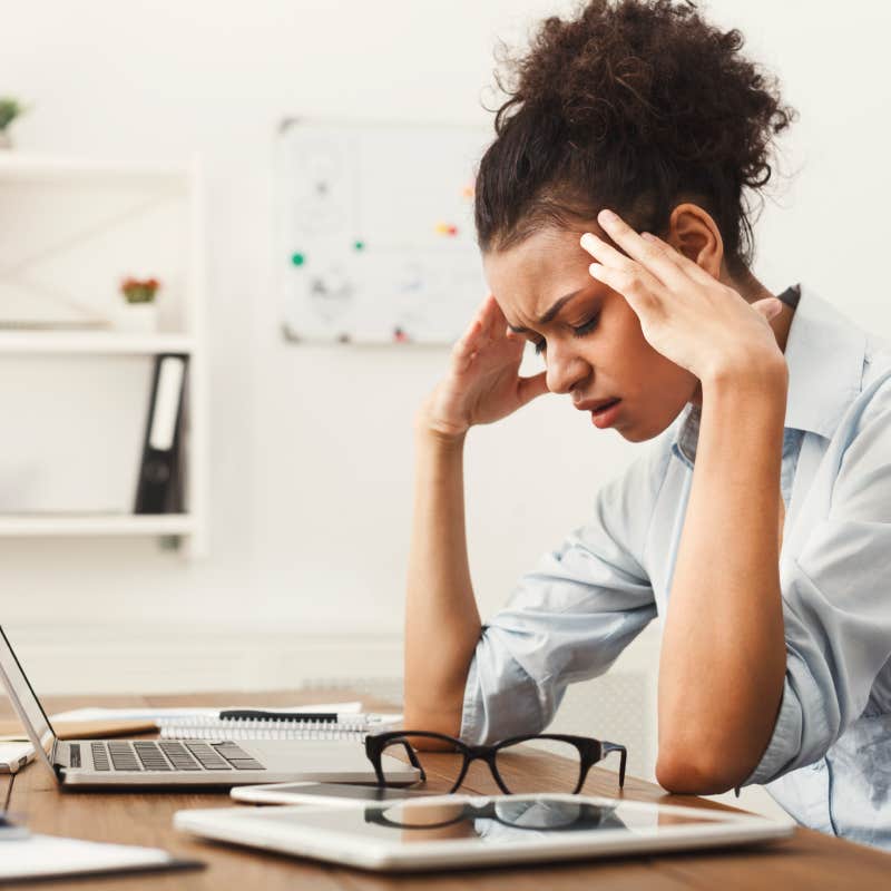 tired employee sitting at desk in front of laptop