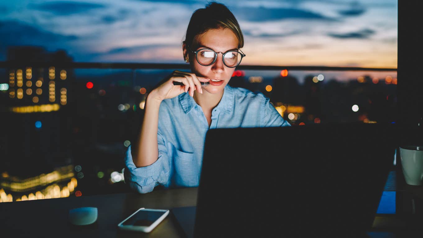 Woman working 80-hour weeks late in the office. 