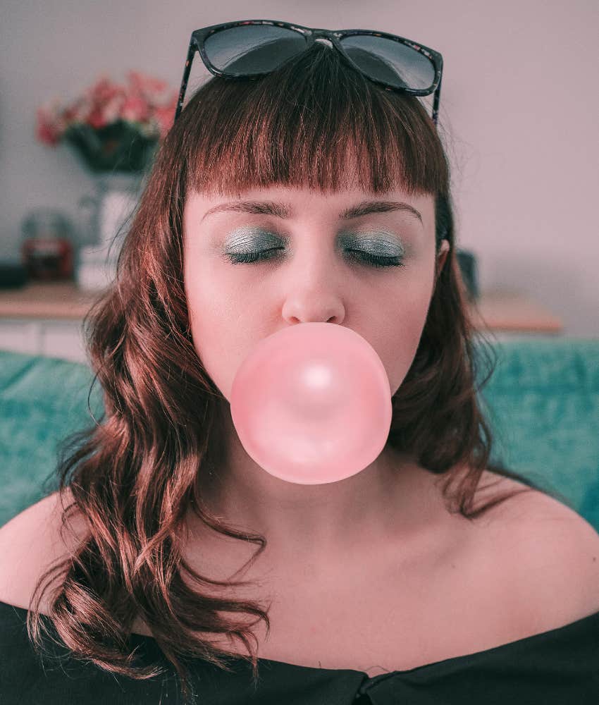 woman blowing a bubble with gum