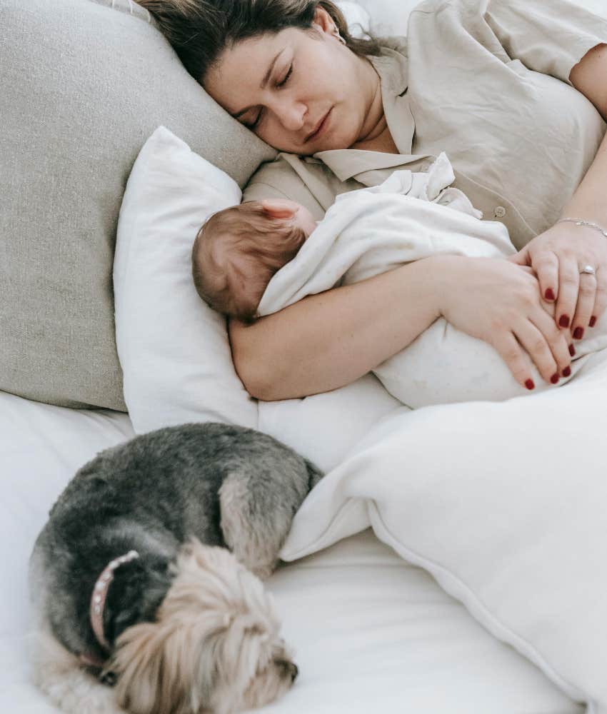 mom and baby sleeping next to dog 